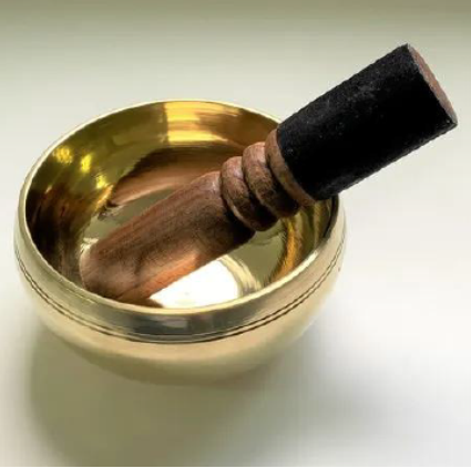 シンギングボウル - ゴールドのボウルと木製スティック